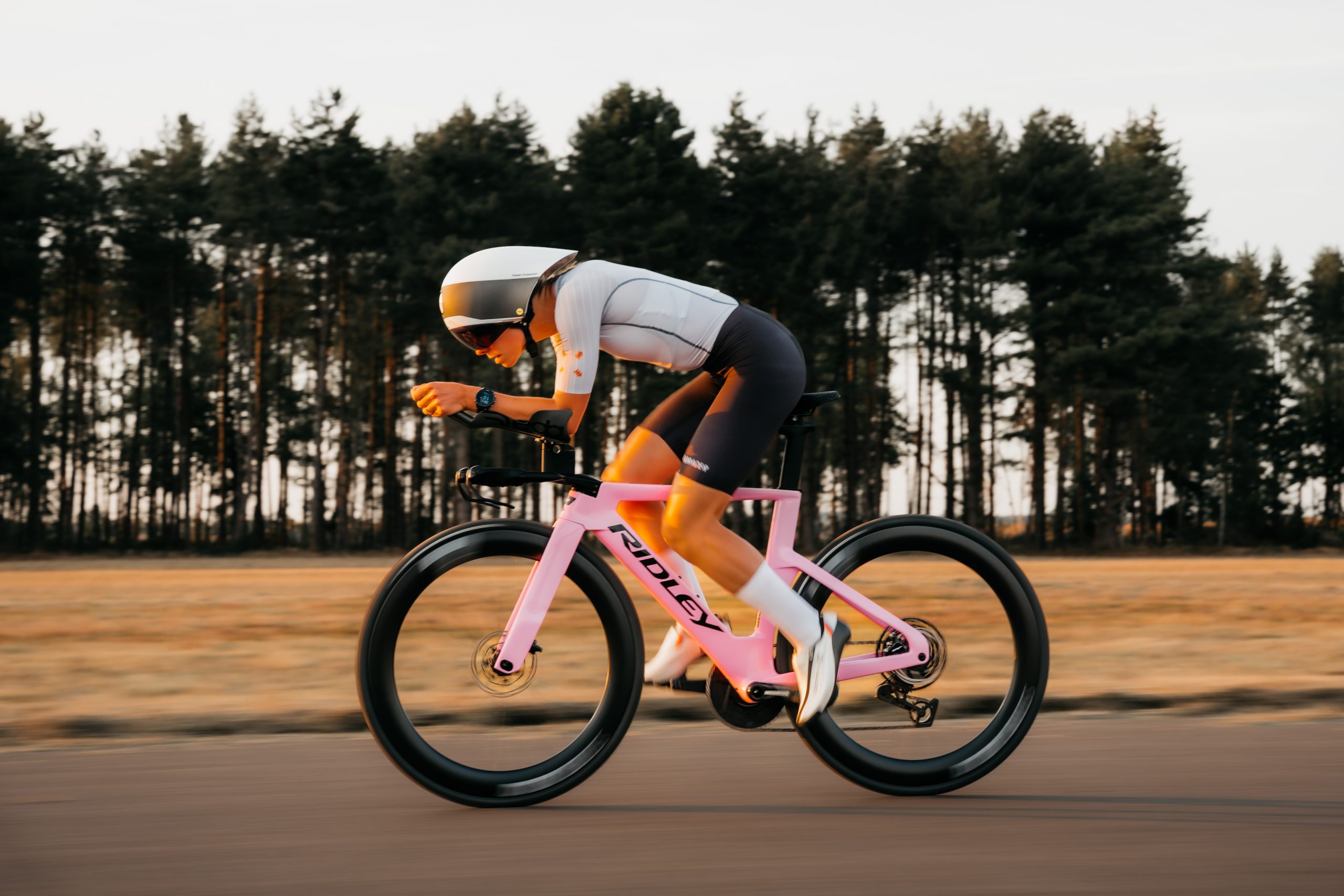 Cyklist från sidan på en rosa Ridley Triton, med cykelskorna i pedalerna.