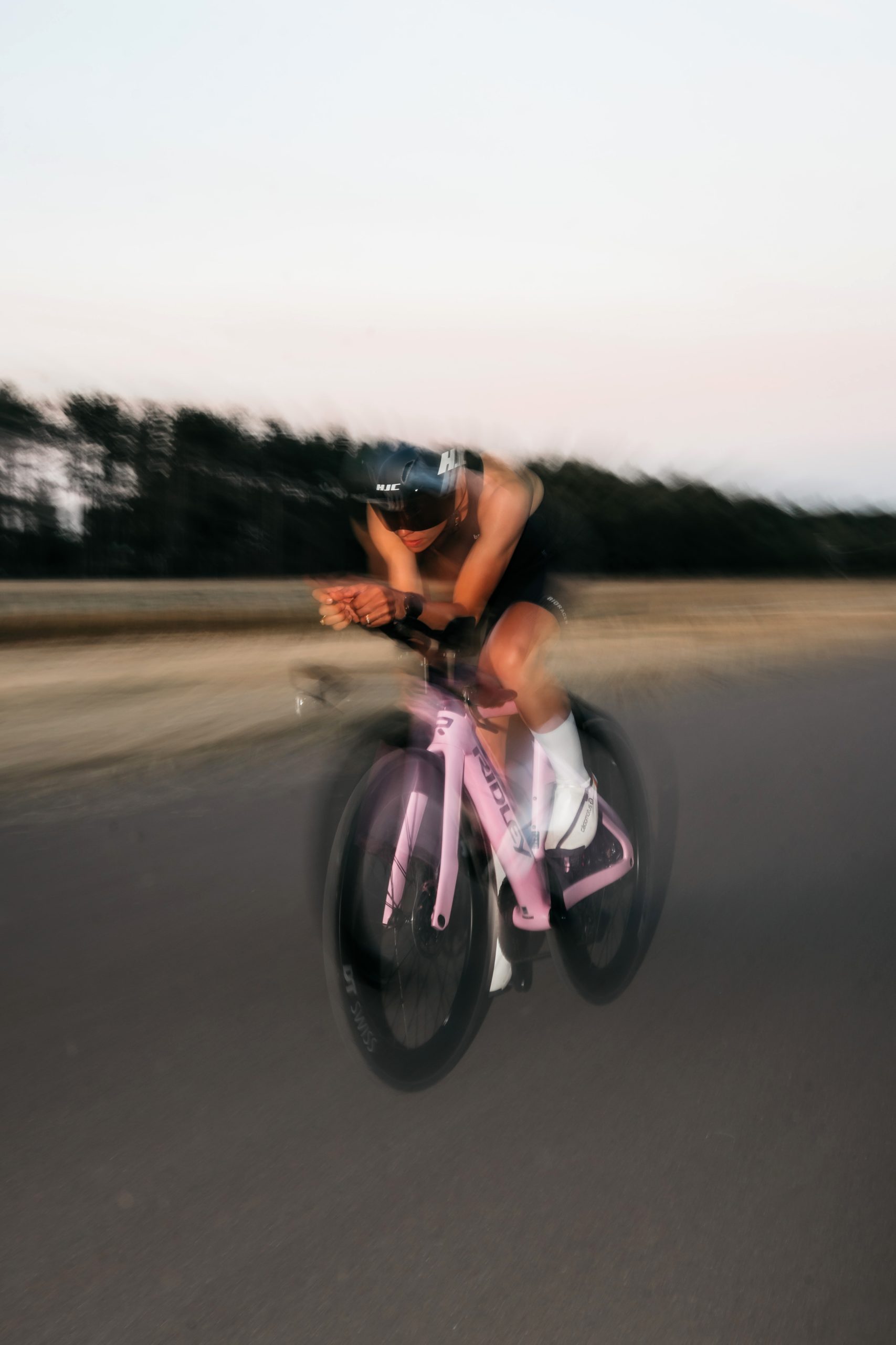Cyklist i aeroposition på en rosa Ridley Triton.